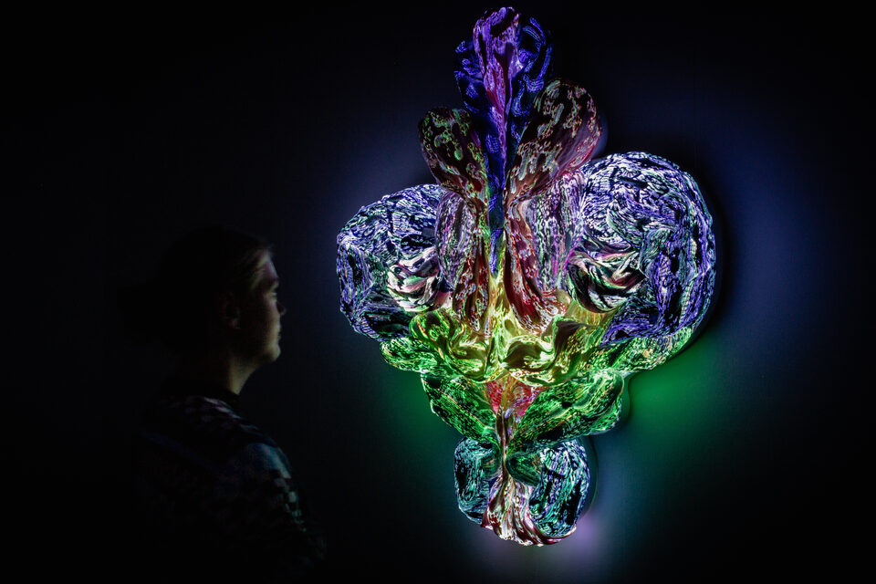 The artwork Andetag no. 25 with a person in the frame showing the textile sculpture's scale.