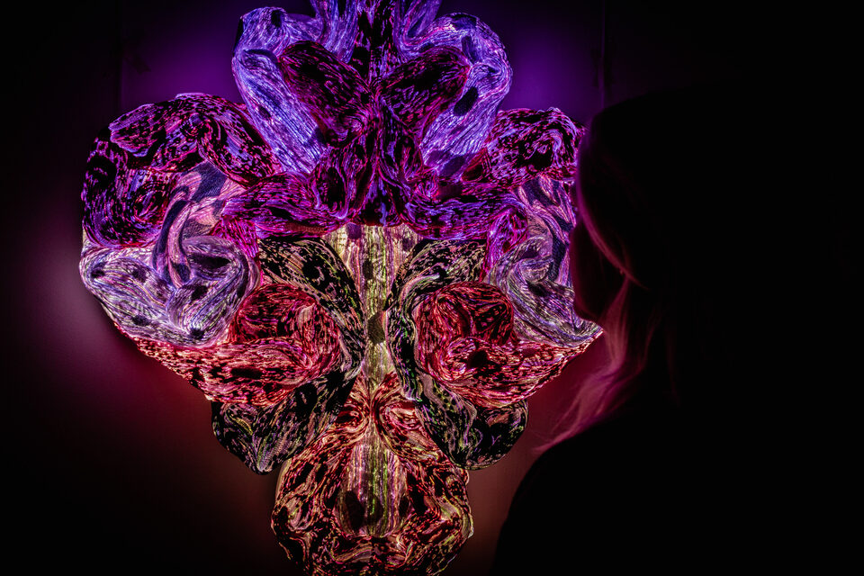 The artwork Andetag no. 37 with a person in the frame showing the textile sculpture's scale.