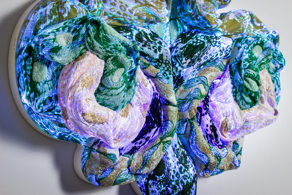 Emerald viewed from the side, the sculpture's depth and texture emphasized.