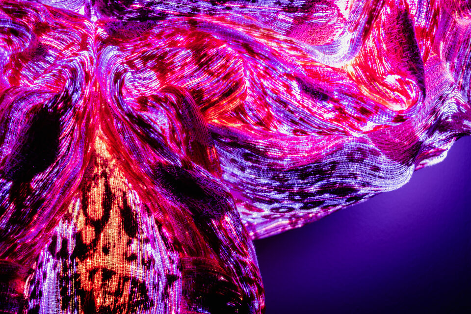 Close-up of Ruby's woven textile, intricate red and crimson threads.