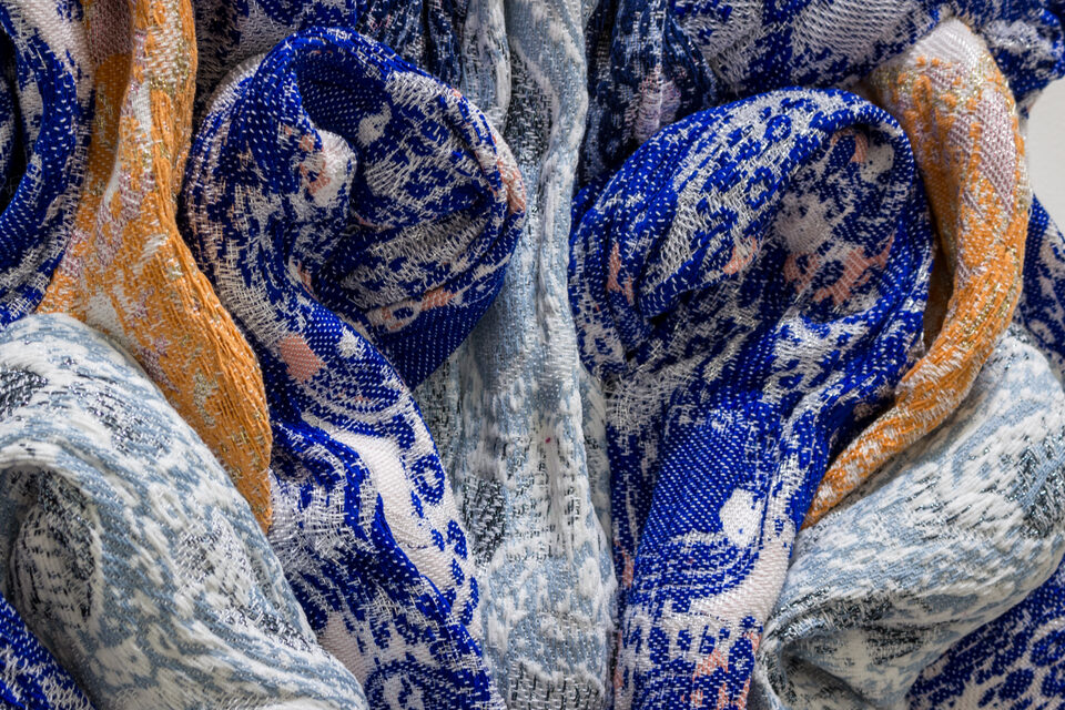 Close-up of Sapphire's woven textile, intricate blue and indigo threads.
