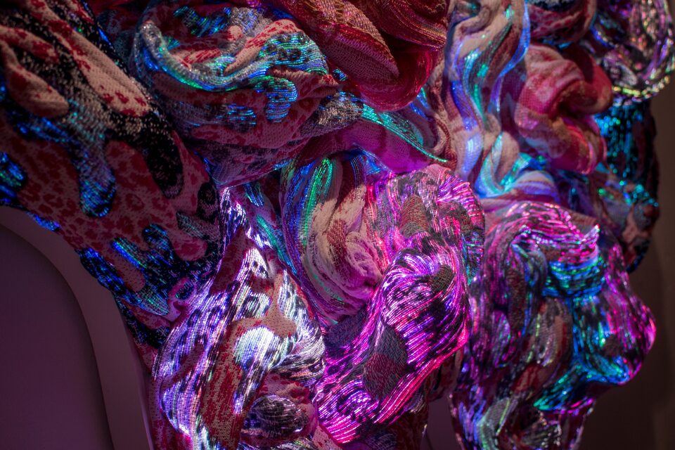 Close-up of optical fibre textile illuminated in magenta, cyan and violet